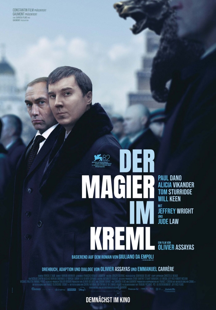 Paul Dano und Jude Law nebeneinander in einer Menschenmenge, die alle in die selbe Richtung schauen - Der Magier im Kreml - Filmplakat