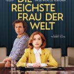 Isabelle Huppert und Laurent Lafitte an einem Tisch mit stoischem Blick zum Zuschauer - Die reichste Frau der Welt